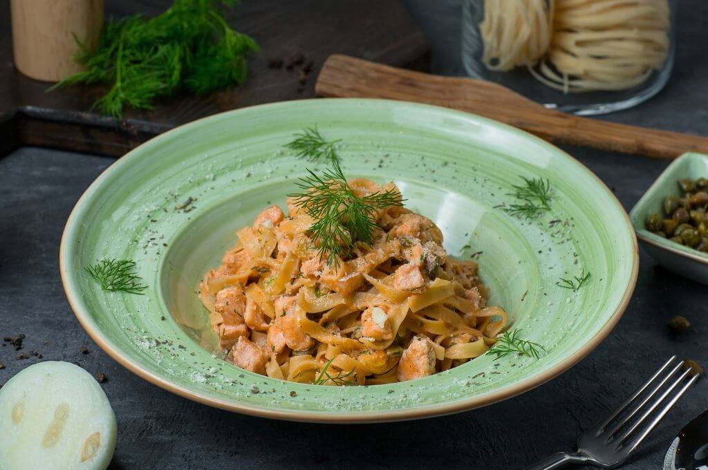 Pasta al pesto con pollo y tocino.